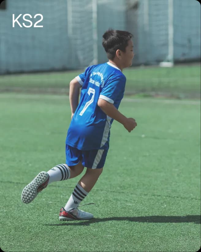 Student playing football on the school field